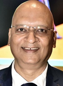 Smiling bald man wearing glasses and a dark suit, looking at the camera.