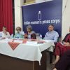Panel discussion at Indian Women's Press Corps with five people seated behind a table, microphones and water bottles on the table.