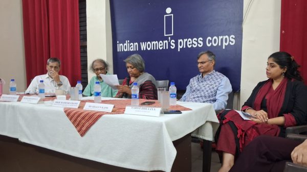 Panel discussion at Indian Women's Press Corps with five people seated behind a table, microphones and water bottles on the table.