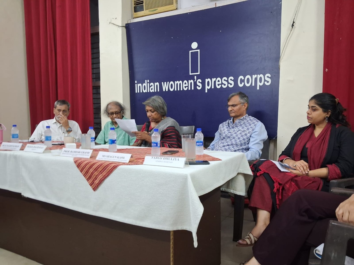 Panel discussion at Indian Women's Press Corps with five people seated behind a table, microphones and water bottles on the table.