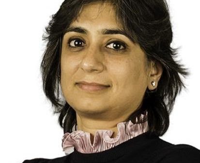 Professional headshot of a woman with short dark hair wearing a black top and pink ruffled collar.