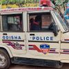 Odisha Police pickup with police insignia and Emergency 112 badge parked on a street.