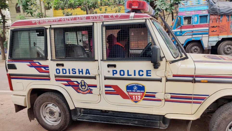 Odisha Police pickup with police insignia and Emergency 112 badge parked on a street.