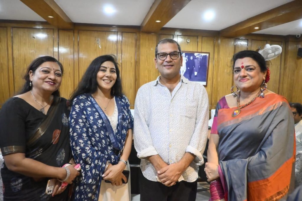 pci_yash | No. 1 Indian Media News Portal Four people posing for a group photo in a wood-paneled room; two women in traditional attire, a man in a light patterned shirt, and another woman in a blue patterned shawl.