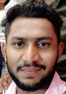 prashant singh | No. 1 Indian Media News Portal Close-up portrait of a smiling man with dark hair and a beard, wearing a pink shirt.