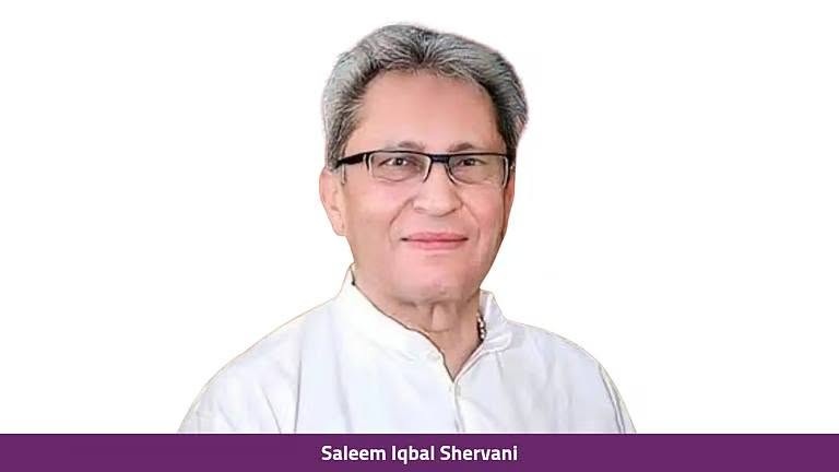 saleem iqbal | No. 1 Indian Media News Portal Portrait of a middle-aged man with gray hair and glasses, wearing a white shirt, posed against a white background.