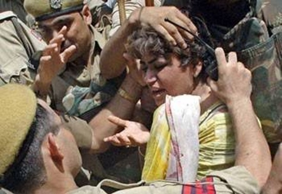 Young boy surrounded by soldiers, distressed as a few hands hold him by the head amid a tense scene