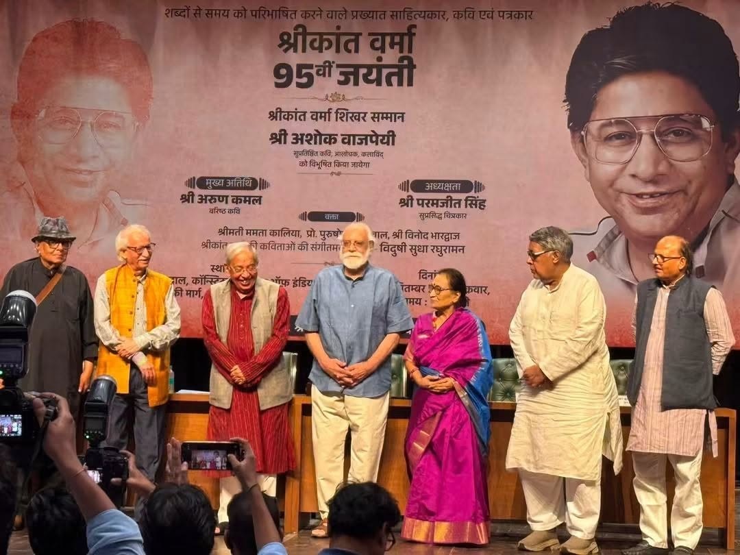 ashok_3 | No. 1 Indian Media News Portal Eight people stand on a stage for a commemorative event, with a large banner announcing '95th Jayanti' in Hindi behind them.