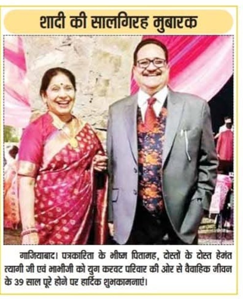 hemant ji 21 | No. 1 Indian Media News Portal Smiling couple at a wedding anniversary celebration; woman in pink saree, man in grey suit; headline reads 'Shadi ki salgirah mubarak' in Hindi.