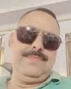 img_0864 | No. 1 Indian Media News Portal Close-up of a man with a mustache wearing dark sunglasses and a light green shirt, looking at the camera.