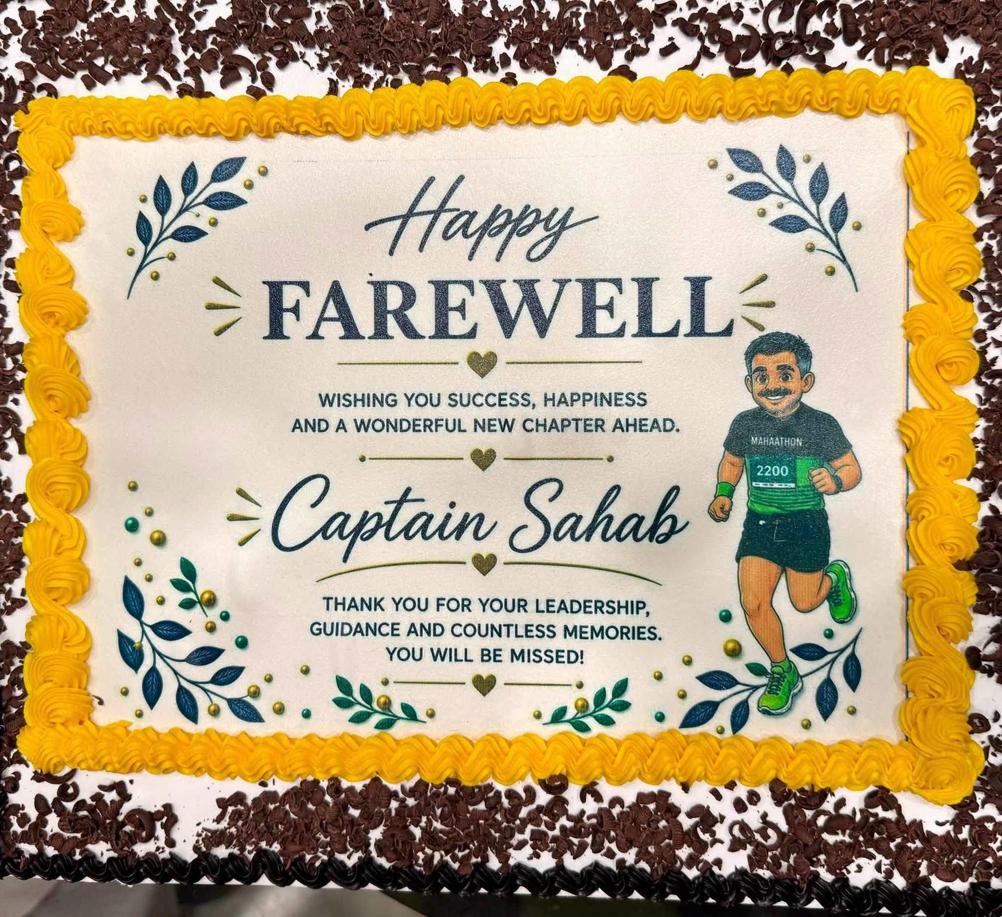 Celebration cake with yellow piped border saying 'Happy Farewell' to Captain Sahab, featuring a cartoon runner and floral decorations.