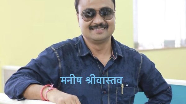 Portrait of a man in a blue denim shirt wearing sunglasses, smiling in an office with a Hindi name overlay: मनिष श्रीवास्तव