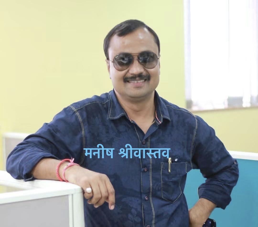 Portrait of a man in a blue denim shirt wearing sunglasses, smiling in an office with a Hindi name overlay: मनिष श्रीवास्तव