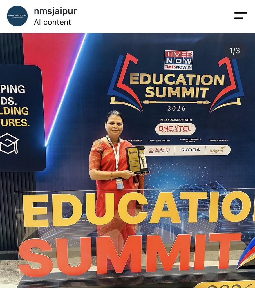 Woman in a red sari holding a trophy in front of a large 'EDUCATION SUMMIT' banner at an event.
