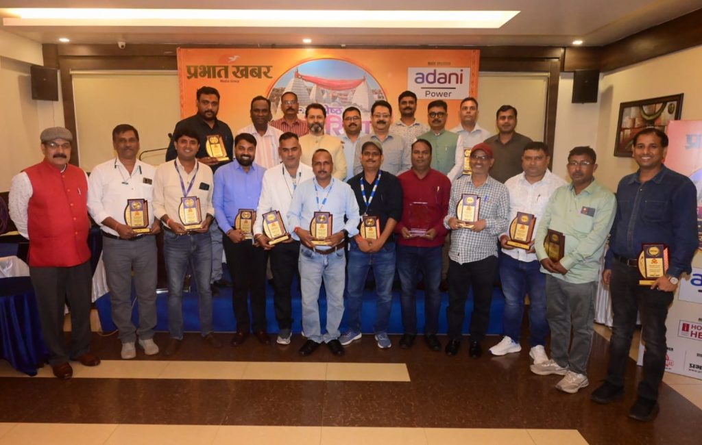 pk deoghar_1 | No. 1 Indian Media News Portal Group of men at an award ceremony posing with plaques on a stage in a conference room with an orange banner behind them (Adani Power).