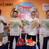 Four men stand side by side, each holding a copy of a newspaper at a press event, with a Prabhat Khabar backdrop and Adani Power logo behind them.