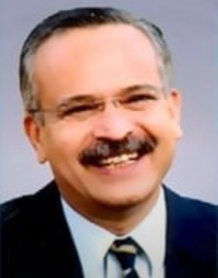 Screenshot | No. 1 Indian Media News Portal Smiling middle-aged man in a suit and tie, photographed in a head-and-shoulders portrait.