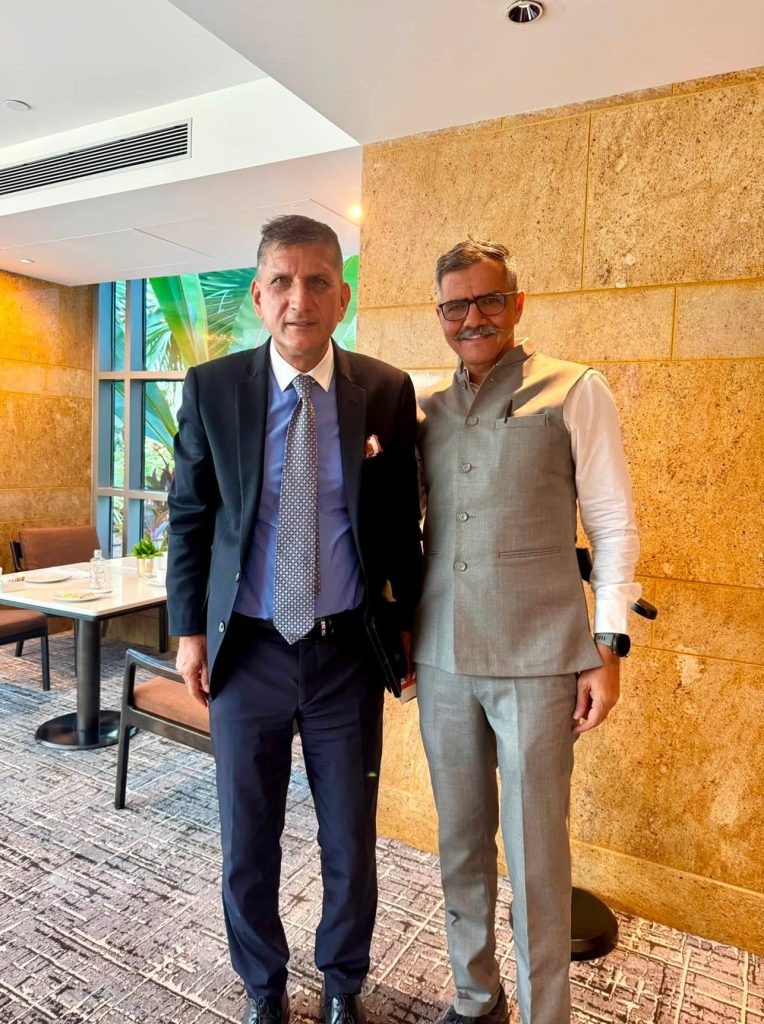 sunder thakur | No. 1 Indian Media News Portal Two businessmen posing together in a restaurant lobby, one in a navy suit and the other in a light gray vest and trousers.
