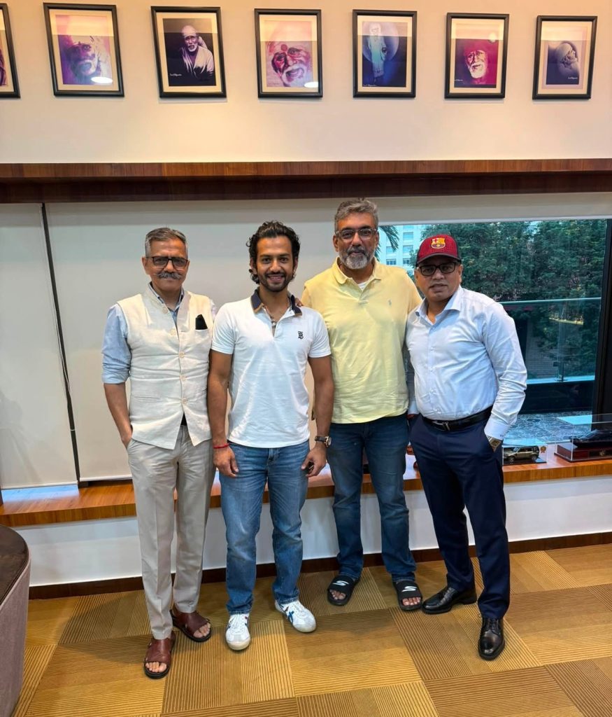 sunder thakur_1 | No. 1 Indian Media News Portal Four men stand together in a room with framed portraits on the wall behind them, posing for a photo.