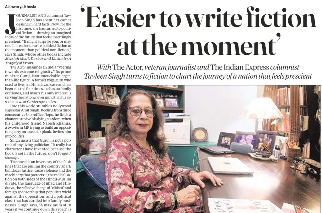 tavleen singh | No. 1 Indian Media News Portal Portrait of a woman seated at a cluttered office desk, next to a large newspaper-style page with the headline “Easier to write fiction at the moment” and a column of text on the left.