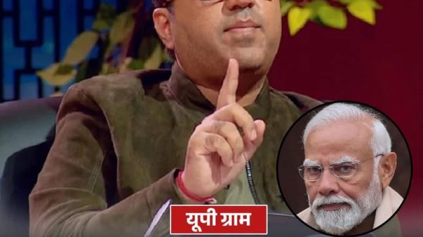 News thumbnail: host with glasses gesturing, inset of Prime Minister Modi, and Hindi headline about UP government controversy and funds.