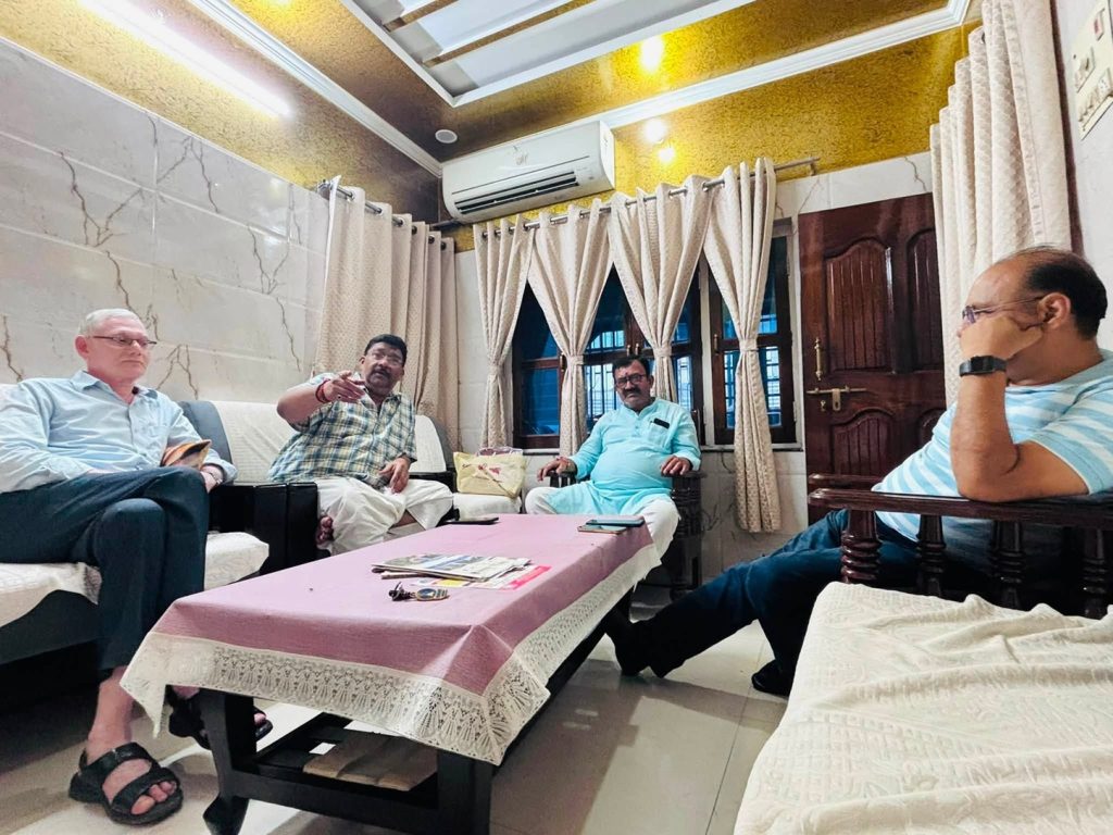 yash_ghazipur_1 | No. 1 Indian Media News Portal Four men sit on couches around a pink coffee table inside a well-lit living room, one gesturing while talking.