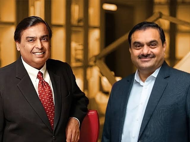 Two men in business suits smiling for the camera in a modern office lobby.