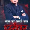 Promotional poster of a man in a dark suit with glasses, arms crossed; bold red headline 'धुरधर' with Hindi tagline and news logos at the bottom.