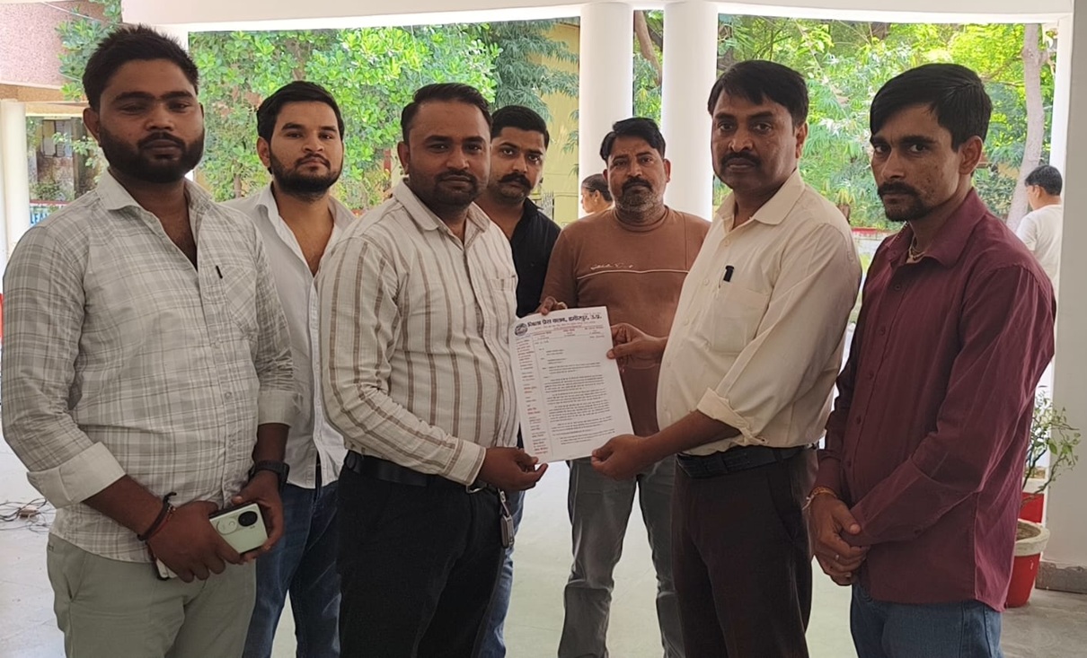 hamirpur | No. 1 Indian Media News Portal Eight men stand in a semi-circle as one hands a document to another during a formal-looking exchange outdoors on a covered patio.