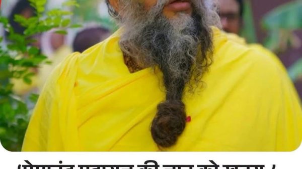News thumbnail: bearded man in bright yellow robes with a tilak, looking upward; Hindi headline about danger to Premanand Maharaj and demand for Z+ security.