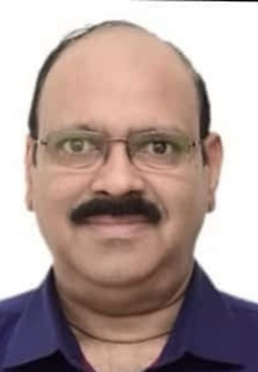 Head-and-shoulders portrait of a middle-aged man with glasses and a mustache, wearing a dark purple shirt.