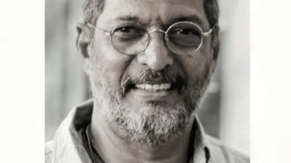 Black-and-white portrait of Nana' Patek ar looking at the camera, with a memorial banner reading 'NANA' PATEKAR 1951–2026' at the bottom