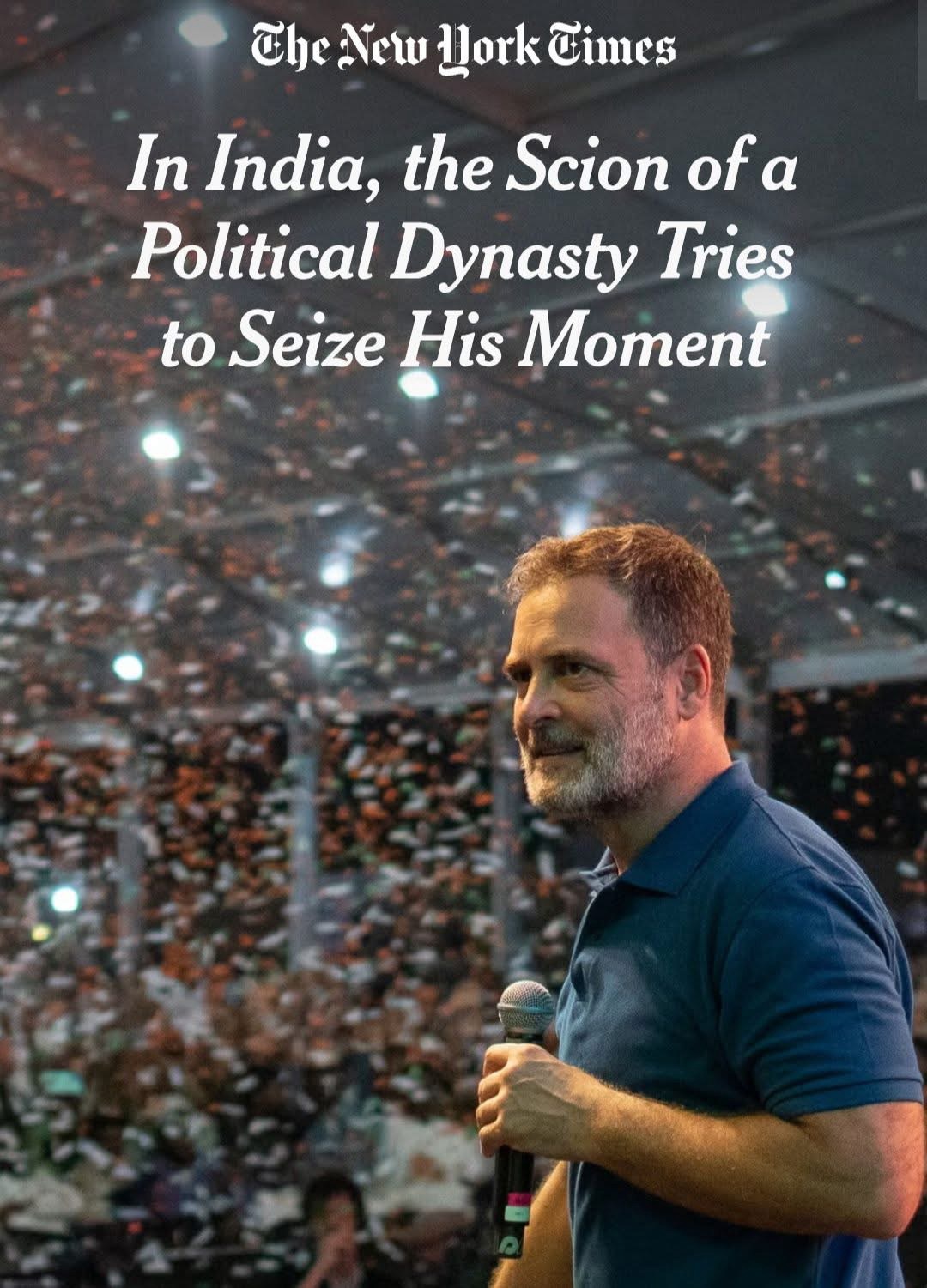 The New York Times headline over a man in a blue polo speaking into a microphone at a crowded stadium.