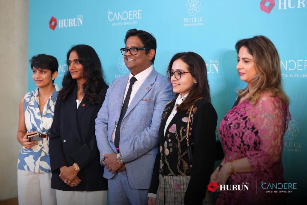 img_2400 | No. 1 Indian Media News Portal Five professionals posing for a photo at an event in front of a blue backdrop with brand logos; center man wears a light-blue suit.