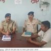Police officers in khaki uniforms sit at a table with a civilian during a briefing about Katihar journalist kidnapping (captioned in Hindi).