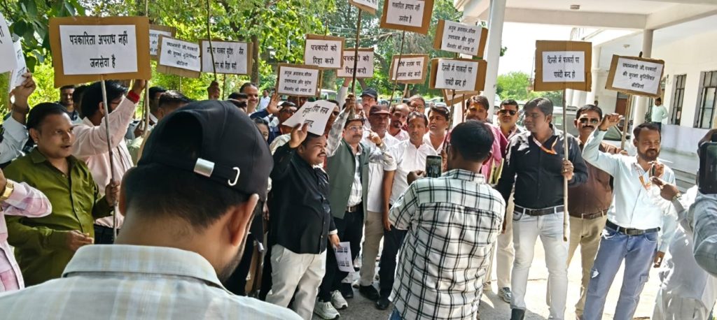 Group of protesters outdoors holding signs with Hindi messages during a daytime demonstration.