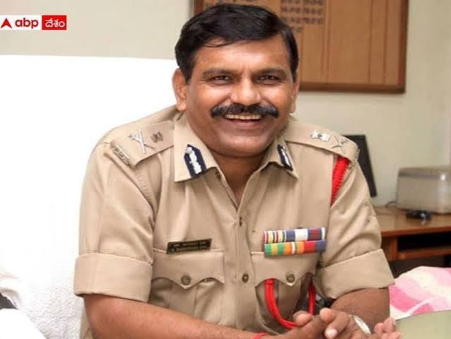 negeshwar | No. 1 Indian Media News Portal Smiling Indian police officer in a beige uniform with service ribbons, seated in an office.