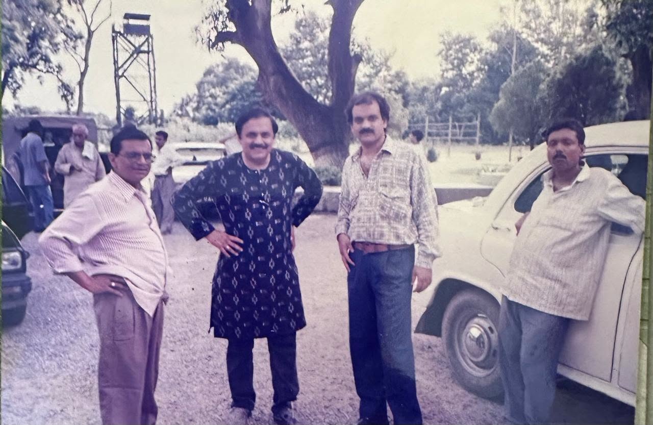 pankaj shukla | No. 1 Indian Media News Portal Four men stand together outdoors beside a white vintage car, with trees in the background.