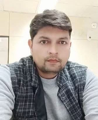 prashant | No. 1 Indian Media News Portal Close-up of a man with short dark hair wearing a gray shirt and plaid vest, looking at the camera in an indoor setting.