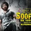 Poster for the film Soorya Ek Yodddha featuring a rugged man with a turban in the foreground, blood splatters, and bold yellow title text on the right.
