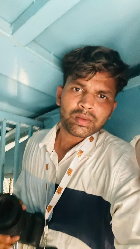 vivek | No. 1 Indian Media News Portal Portrait of a man with dark hair in a white shirt and a patterned lanyard, looking at the camera in a blue-painted stairwell.