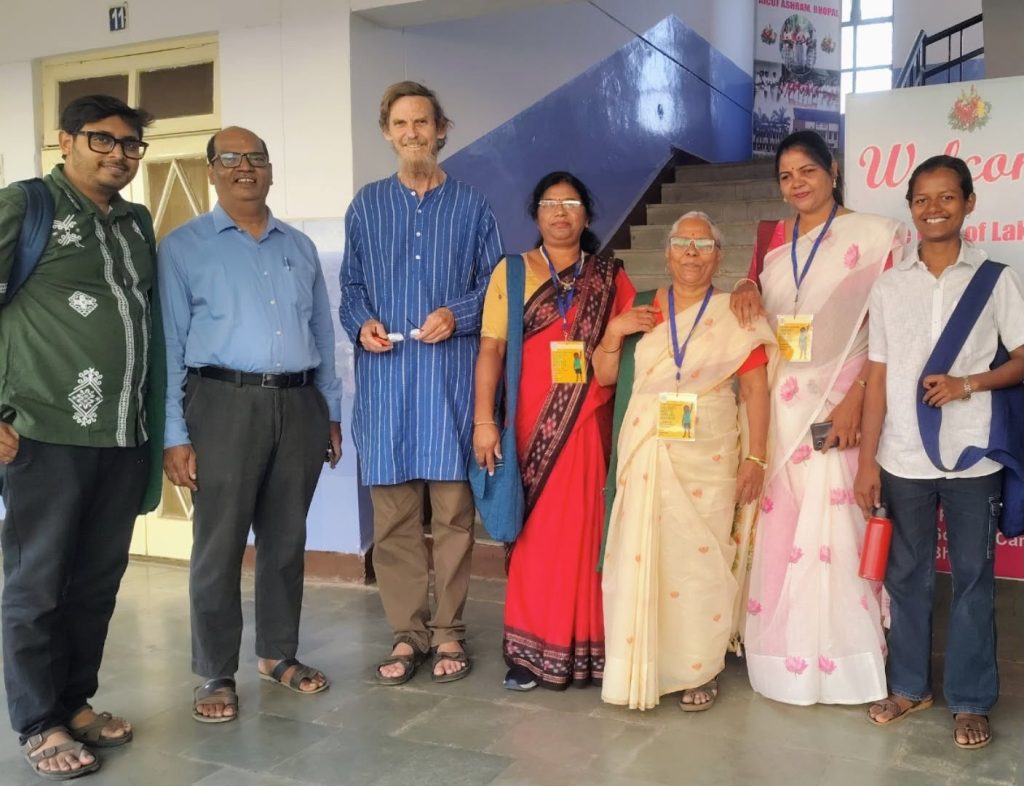 zean_3 | No. 1 Indian Media News Portal Group of seven people posing for a photo in a hallway, some wearing badges and lanyards, smiling at the camera.