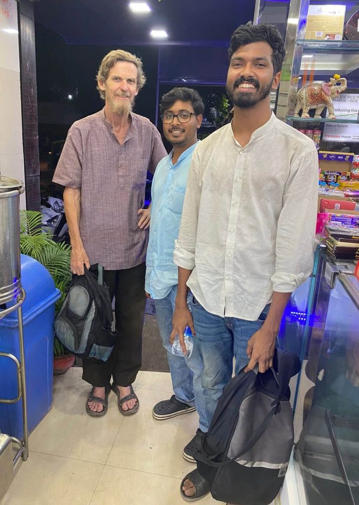 zean_rohin | No. 1 Indian Media News Portal Three men posing and smiling inside a shop, one holding a backpack with shelves of snacks behind them
